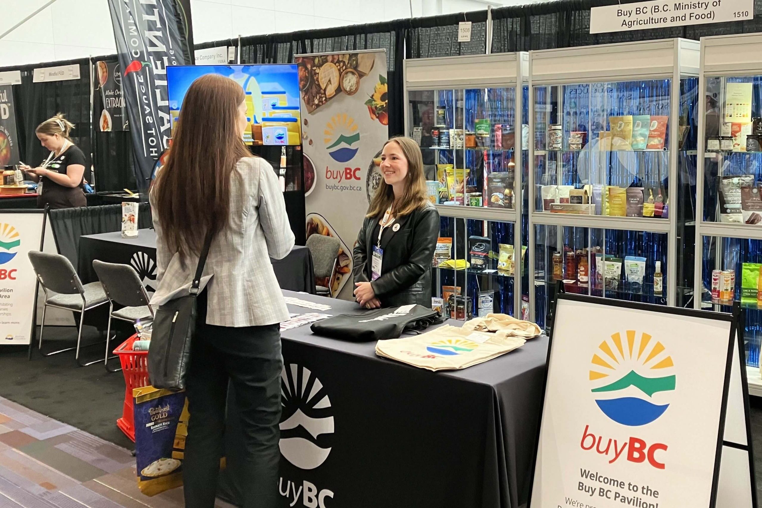 Buy BC team member talking with an attendee in the Buy BC Pavilion at the 2024 Grocery & Specialty Food West Tradeshow